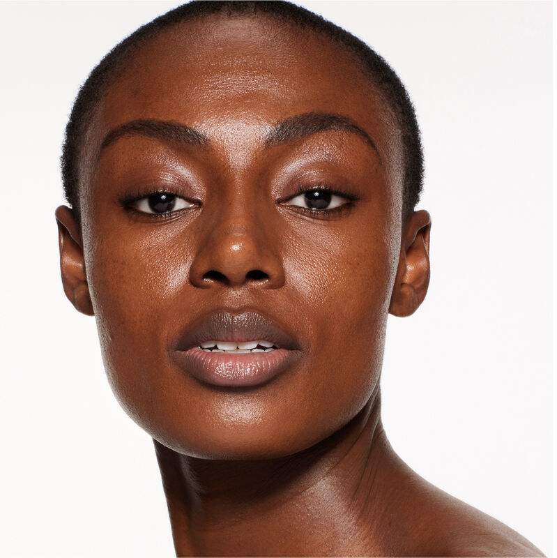 "A headshot of a model wearing the Shiseido Revitalessence Skin Glow Foundation SPF 30 in shade 530 Henna. The models’ skin appears more smooth and glowy with the foundation's medium-coverage finish.  "