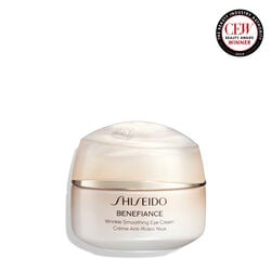 Un frasco redondo, color melocotón de la crema Shiseido Benefiance Wrinkle Smoothing Eye Cream. El frasco cerrado muestra el nombre del producto en inglés y francés.