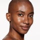 "A headshot of a model wearing the Shiseido Revitalessence Skin Glow Foundation SPF 30 in shade 460 Topaz. The models’ skin appears more smooth and glowy with the foundation's medium-coverage finish.  "
