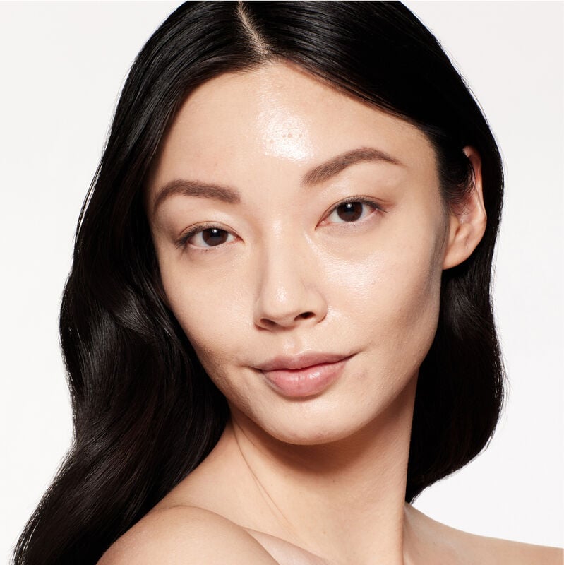 A headshot of a model wearing the Shiseido Revitalessence Skin Glow Foundation SPF 30 in shade 210 Birch. The models’ skin appears more smooth and glowy with the foundation's medium-coverage finish.