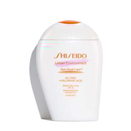 A  closed, rounded white bottle of Shiseido Urban Environment Oil-Free Sunscreen SPF 42 143mL against a white background. The label includes the product name, as well as describing that it is oil-free, contains hyaluronic acid, is a broad spectrum product, and is water resistant up to 40 minutes. The image also states that this product is recommended for daily use by the Skin Cancer Foundation, and it is also a US Winner for Marie Claire’s Prix D’Excellence De La Beauté 2023.  