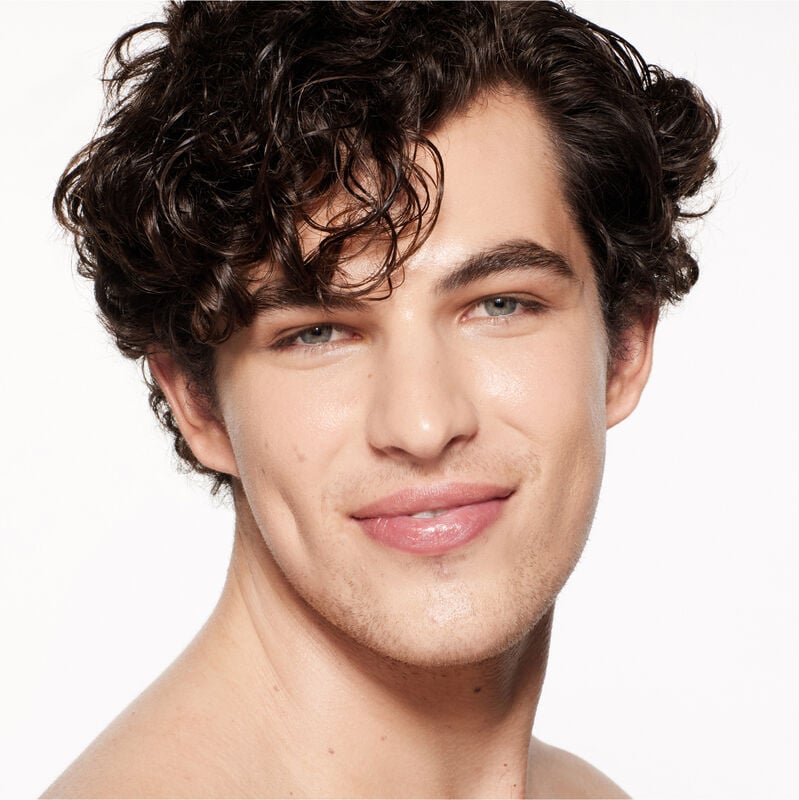 "A headshot of a model wearing the Shiseido Revitalessence Skin Glow Foundation SPF 30 in shade 230 Alder. The models’ skin appears more smooth and glowy with the foundation's medium-coverage finish.  "