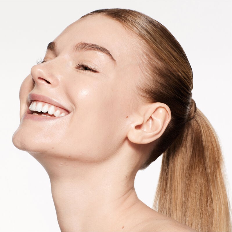 A headshot of a model wearing the Shiseido Revitalessence Skin Glow Foundation SPF 30 in shade 160 Shell. The models’ skin appears more smooth and glowy with the foundation's medium-coverage finish.