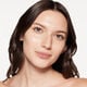 A headshot of a model wearing the Shiseido Revitalessence Skin Glow Foundation SPF 30 in shade 240 Quartz. The models’ skin appears more smooth and glowy with the foundation's medium-coverage finish.