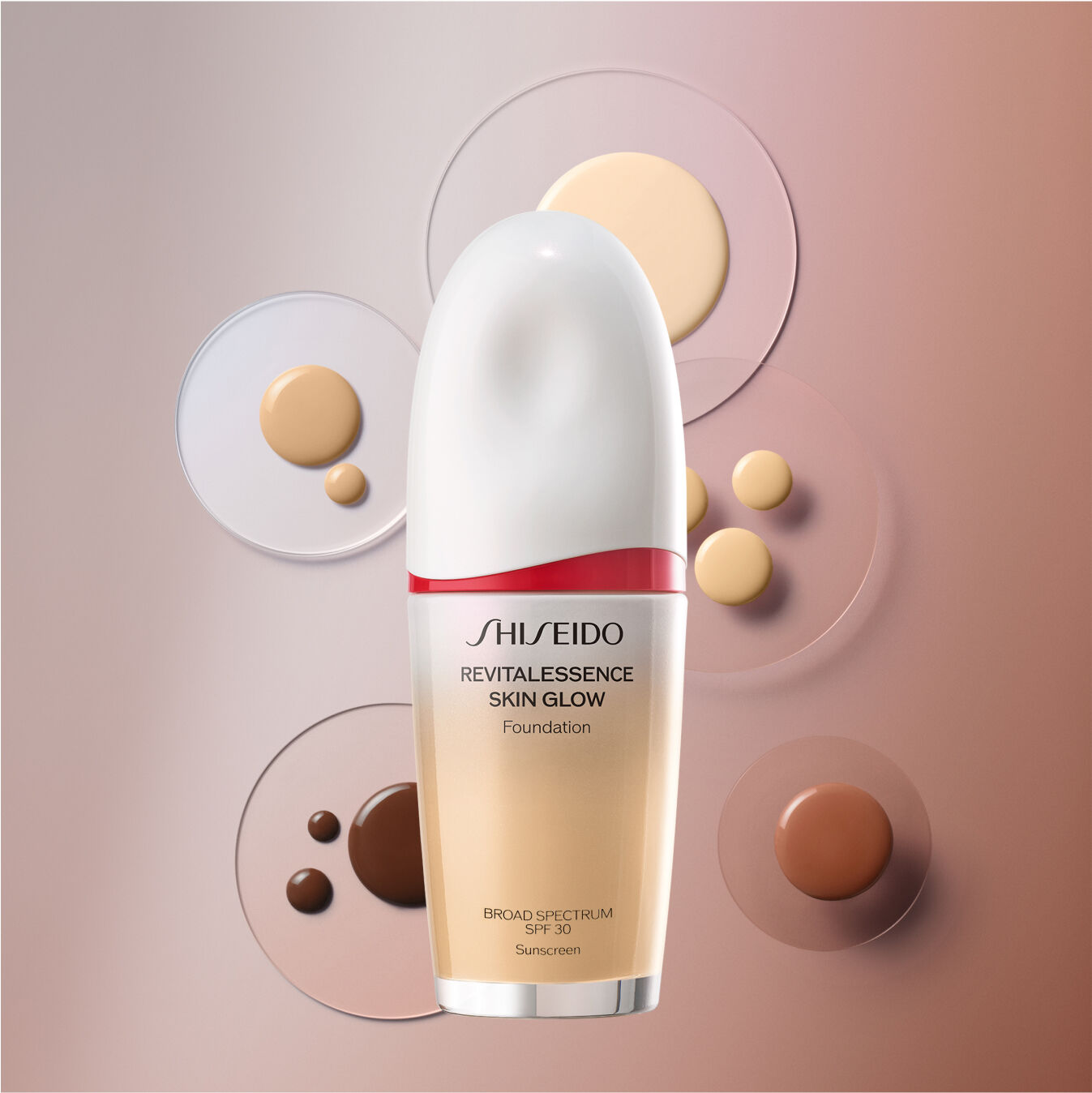 Un frasco de la base de maquillaje Shiseido Revitalessence Skin Glow Foundation SPF 30 sobre un fondo marrón, salpicado con varios círculos pequeños de base de maquillaje en diferentes colores para mostrar su textura similar a la de un suero, disponible en una amplia gama de tonos.