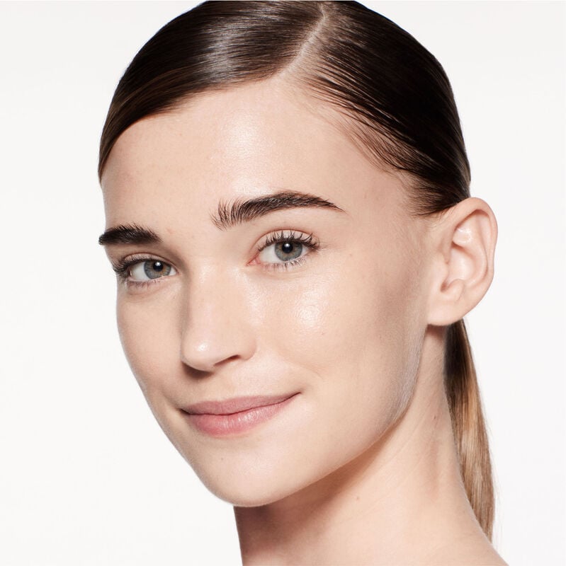 "A headshot of a model wearing the Shiseido Revitalessence Skin Glow Foundation SPF 30 in shade 130 Opal. The models’ skin appears more smooth and glowy with the foundation's medium-coverage finish.  "