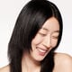 A headshot of a model wearing the Shiseido Revitalessence Skin Glow Foundation SPF 30 in shade 150 Lace. The models’ skin appears more smooth and glowy with the foundation's medium-coverage finish.