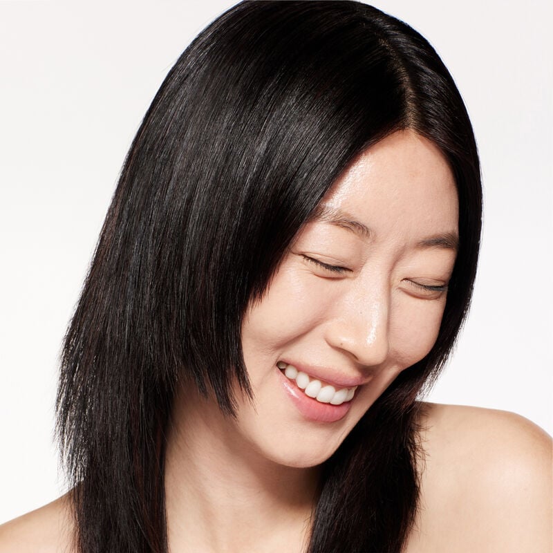 A headshot of a model wearing the Shiseido Revitalessence Skin Glow Foundation SPF 30 in shade 150 Lace. The models’ skin appears more smooth and glowy with the foundation's medium-coverage finish.