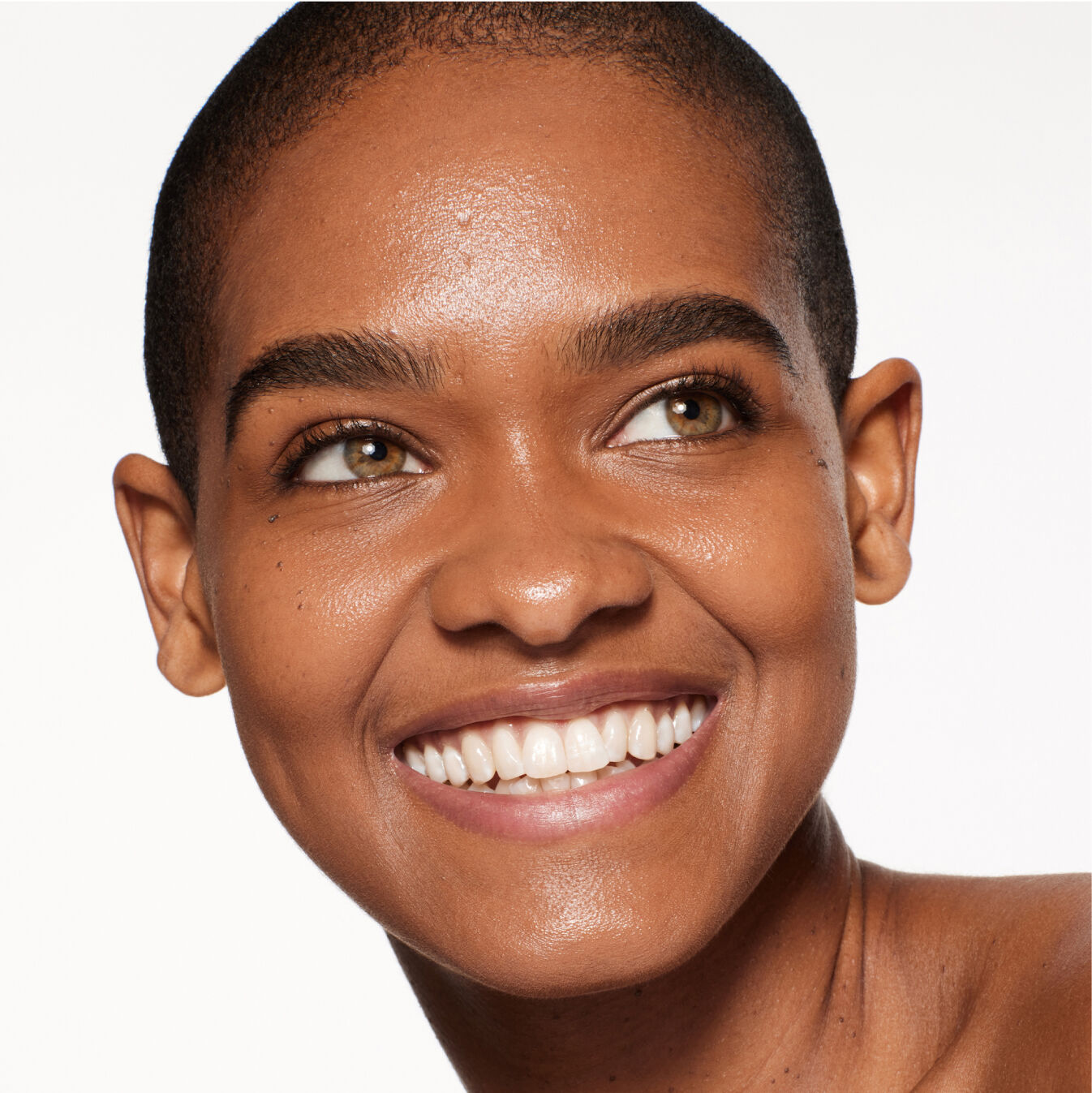 "Retrato de un modelo usando Shiseido Revitalessence Skin Glow Foundation SPF 30 en el tono 440 Amber. La piel de la modelo luce más uniforme y luminosa gracias al acabado de cobertura media del maquillaje".