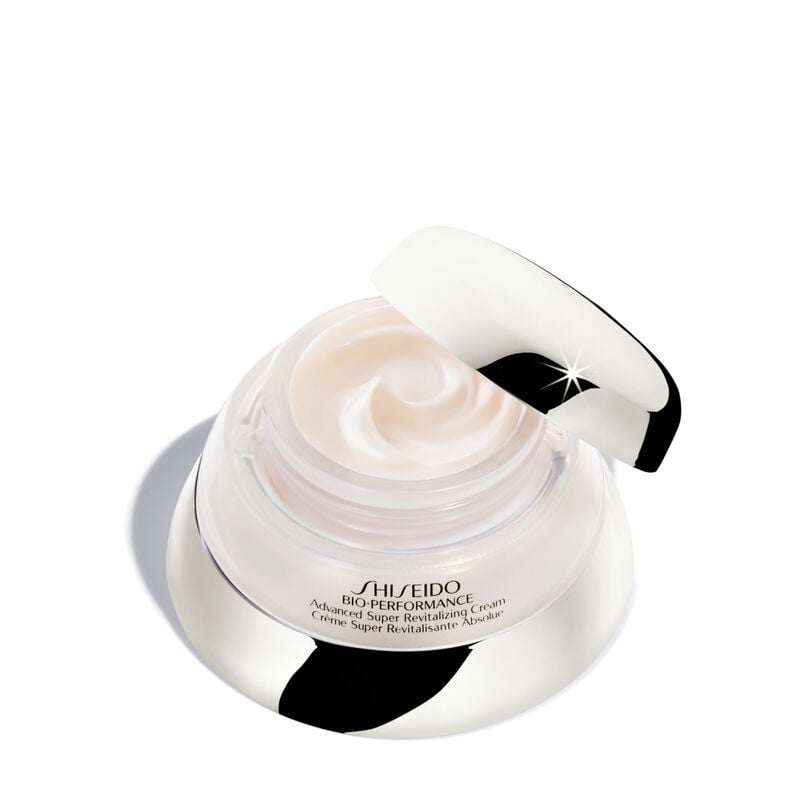 "An open jar of Bio-Performance Advanced Super Revitalizing Cream. The jar reveals the rich-textured cream inside. It is labeled with the Shiseido logo and the product name in both English and French. "