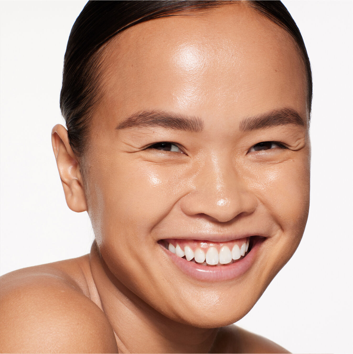 "Retrato de un modelo usando Shiseido Revitalessence Skin Glow Foundation SPF 30 en el tono 350 Maple. La piel de la modelo luce más uniforme y luminosa gracias al acabado de cobertura media del maquillaje".